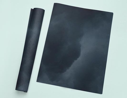 a picture of a black cloud with a roll of black paper next to it